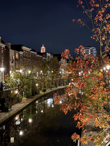916069 Gezicht op de Oudegracht te Utrecht, vanaf de Zandbrug, bij avond.